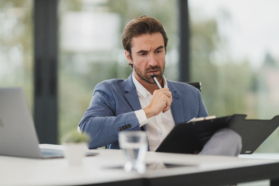 Person reviewing a document at a desk, representing checking an agency proposal's AI claims