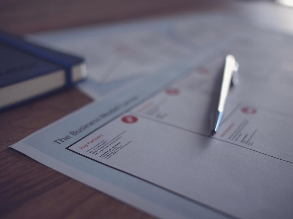 Close-up of a business document with a pen, representing the written content of an SEO proposal.