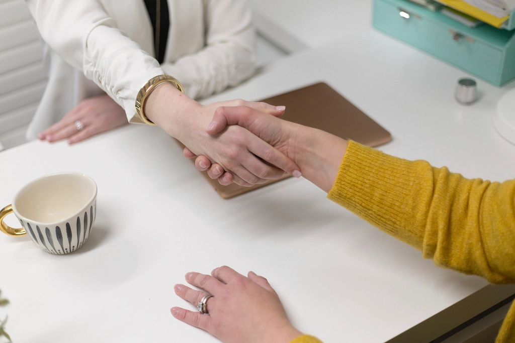 Two people shaking hands at the end of a business meeting, representing the decision to hire an SEO agency.