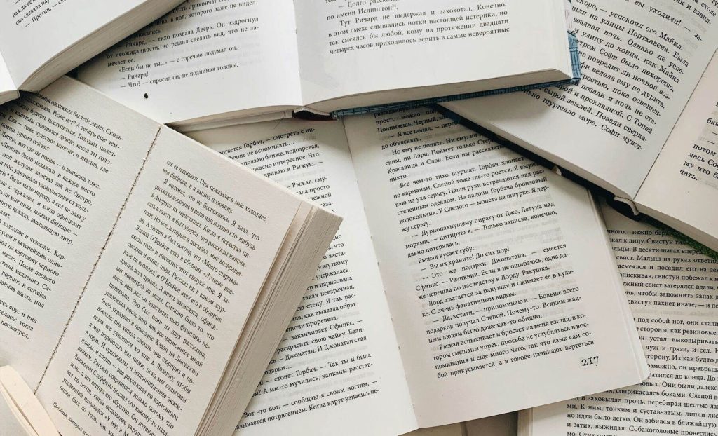 multiple books laid out open on the floor with small text